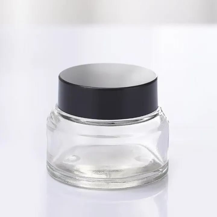Clear slanted shoulder glass cream jar with black cap
