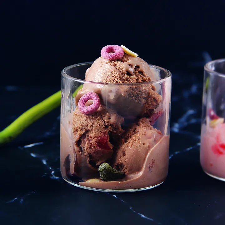 Круглая стеклянная десертная чашка, наполненная шоколадным мороженым