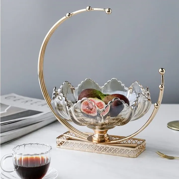 Corbeille à fruits en verre en forme de fleur posée sur un socle décoratif doré