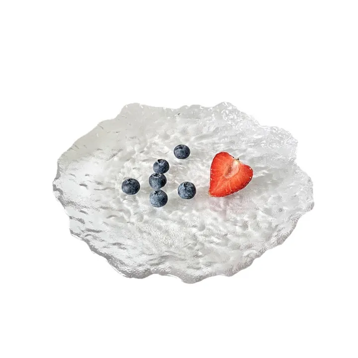 Plat à fruits en verre transparent de forme irrégulière, avec une texture glacée et des baies
