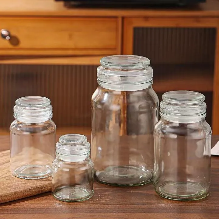 Aufbewahrungsgläser aus klarem Glas mit Glasdeckeln auf einer Holztischplatte