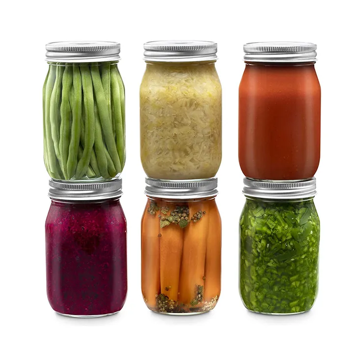 Bocaux en verre contenant des sauces à base de légumes et des conserves