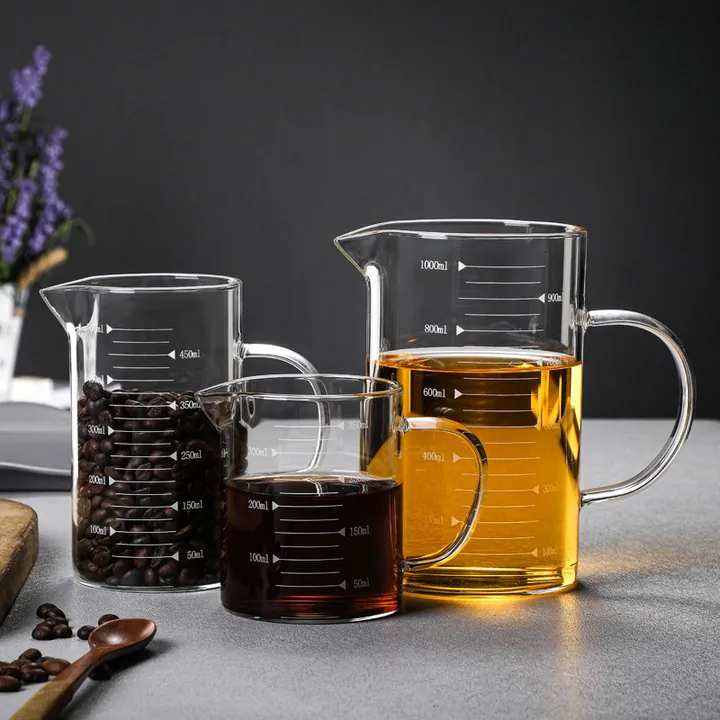 Three glass measuring cups displayed with coffee beans and beverages