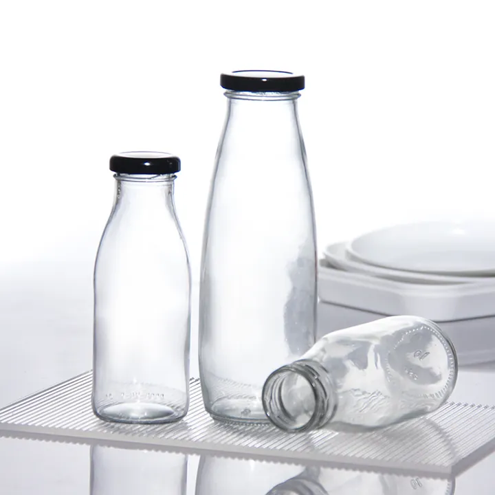 Drei Milchflaschen aus klarem Glas in verschiedenen Größen