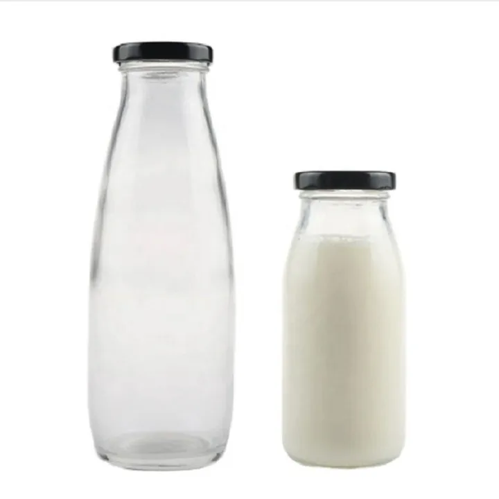 Hohe und niedrige Milchflaschen aus Glas mit schwarzen Verschlüssen