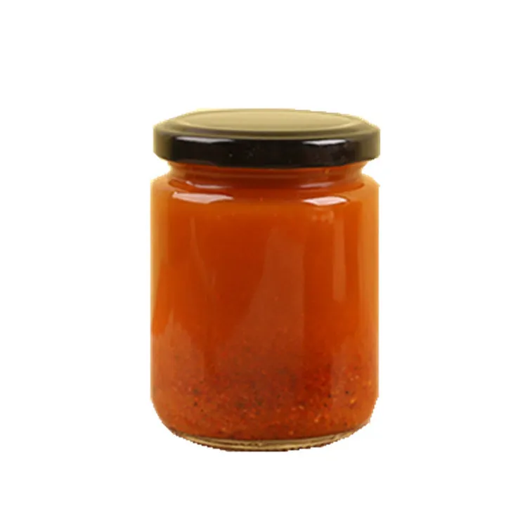 Круглая стеклянная банка для маринованных овощей, наполненная красным соусом, с металлической крышкой цвета «черного золота»