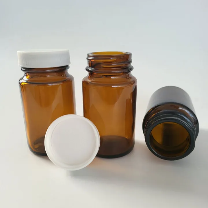 Three amber glass pill bottles with white plastic caps