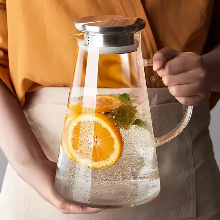 Glaskanne mit Edelstahldeckel, gefüllt mit Orangenscheiben