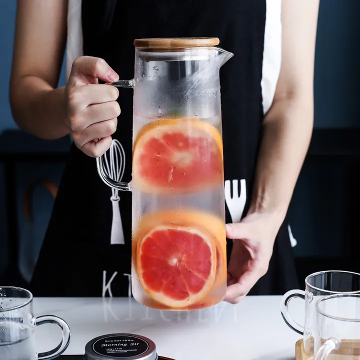 Pichet en verre avec couvercle en bois, rempli d'eau au pamplemousse