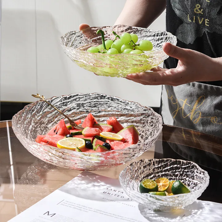 Textured glass bowls filled with assorted fruits on a tabletop