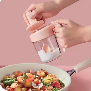 Pink press spoon lid glass spice jar held by hand