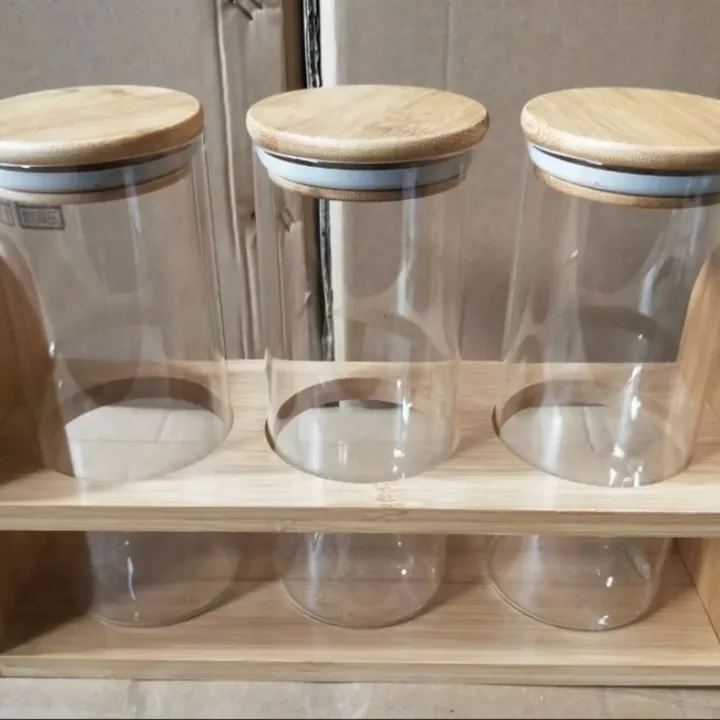 Glass spice jars with bamboo lids placed in a wooden rack