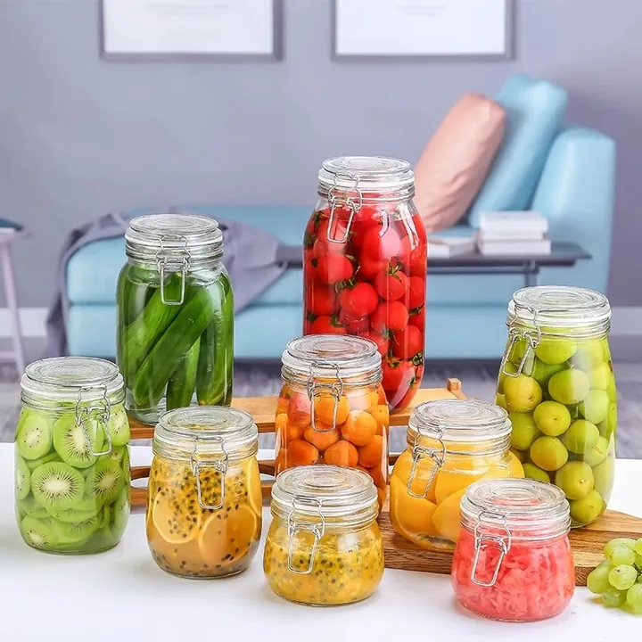 Glass clip top storage jars holding fruit in an indoor setting