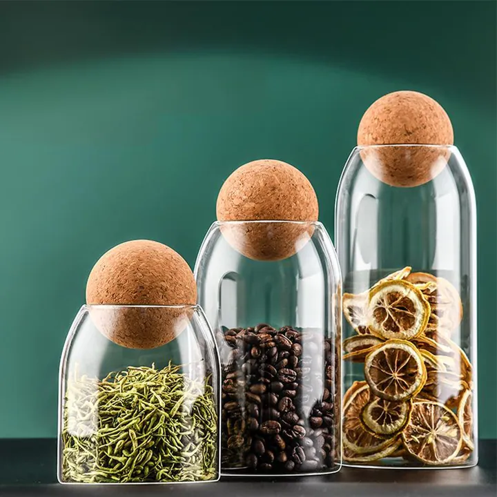 Aufbewahrungsgläser aus klarem Glas mit Korkkugel-Deckeln, in denen Tee, Kaffeebohnen und Trockenobst aufbewahrt werden