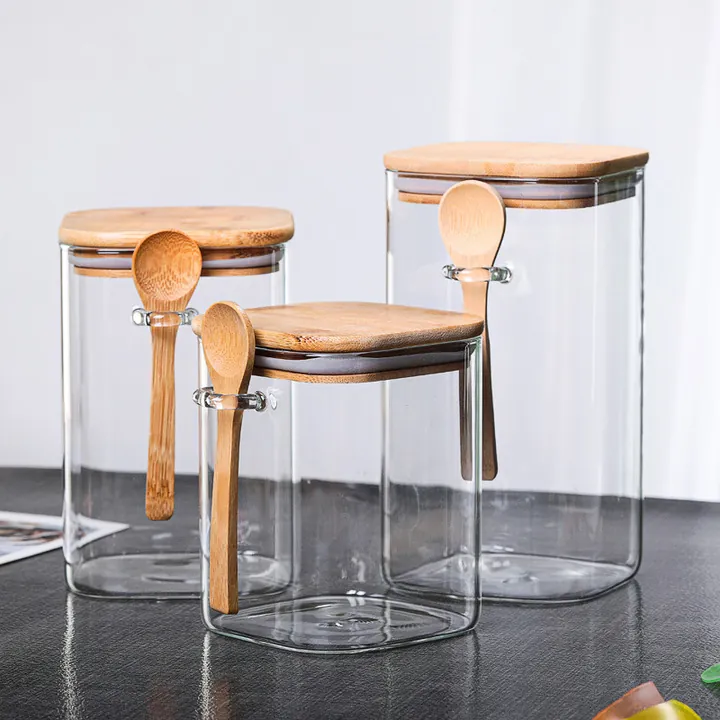 Quadratische Vorratsgläser aus klarem Glas mit Bambusdeckeln und integrierten Holzlöffeln
