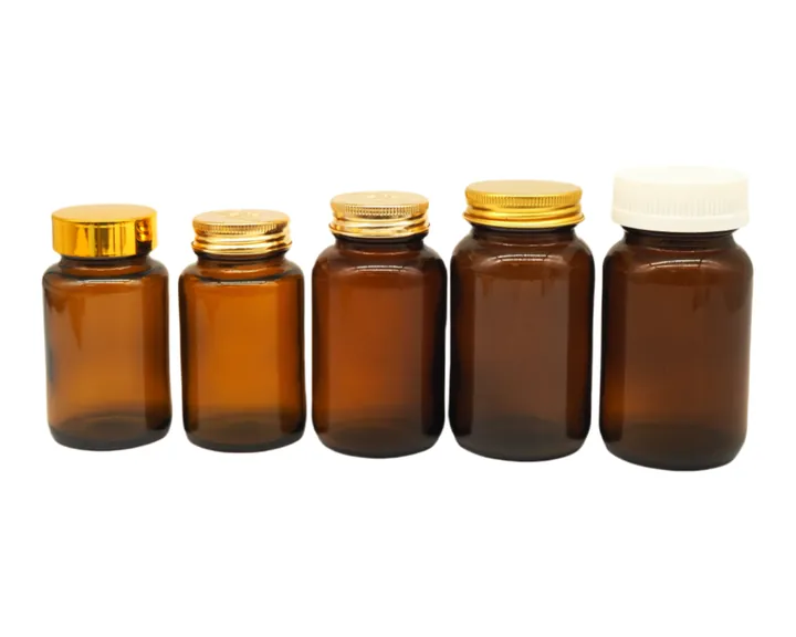 Five amber medicine glass bottles with different colored caps