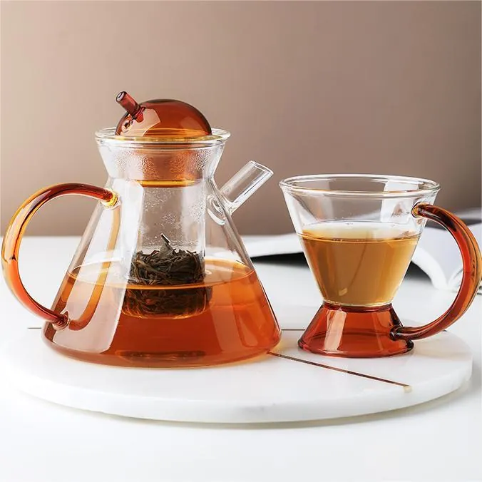 Glass teapot and cups with amber-colored accents