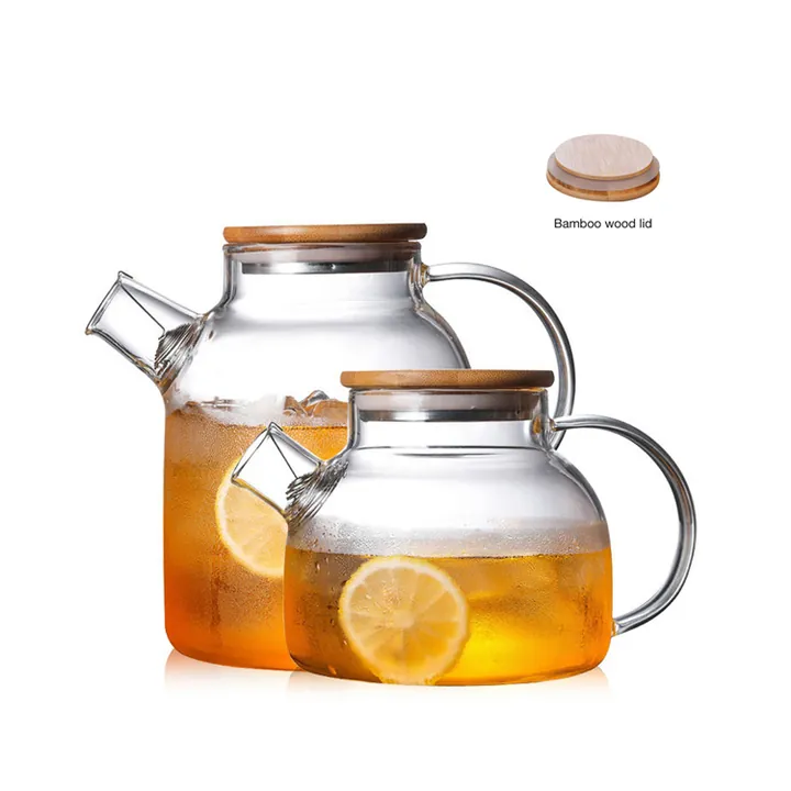 Deux théières en verre transparent avec des couvercles en bambou et du thé au citron