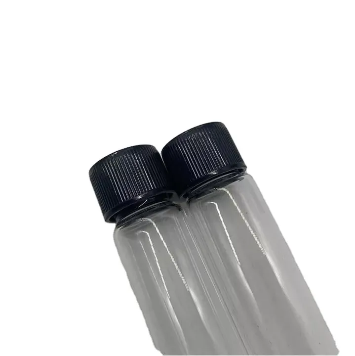 Close-up of transparent glass tubes with black threaded caps