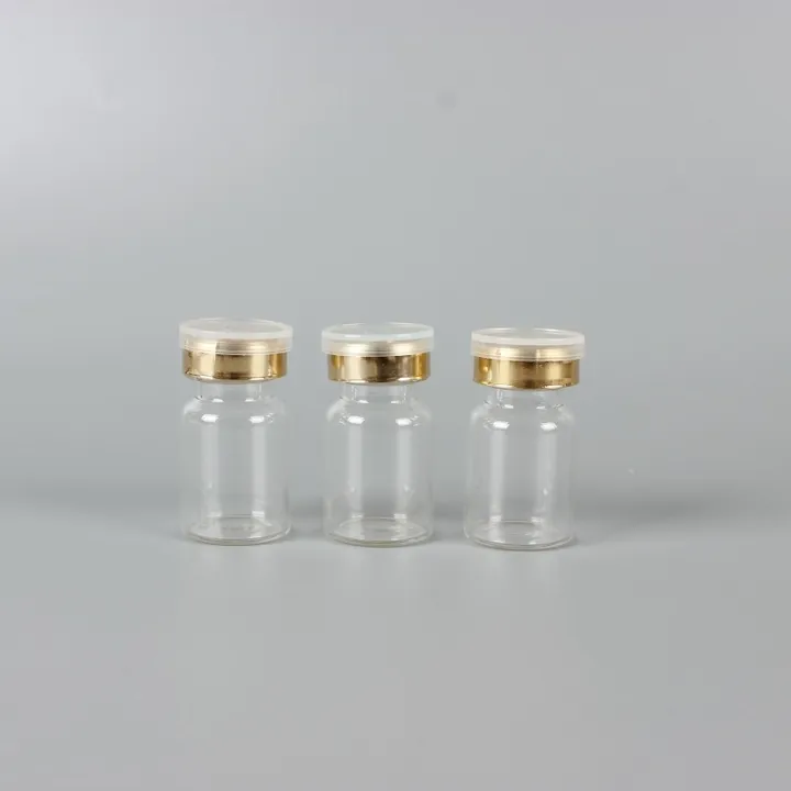Three clear glass vials with gold caps