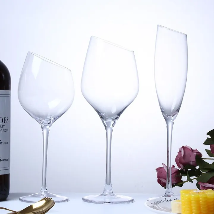 Copas de vino de borde inclinado con una botella de vino y flores