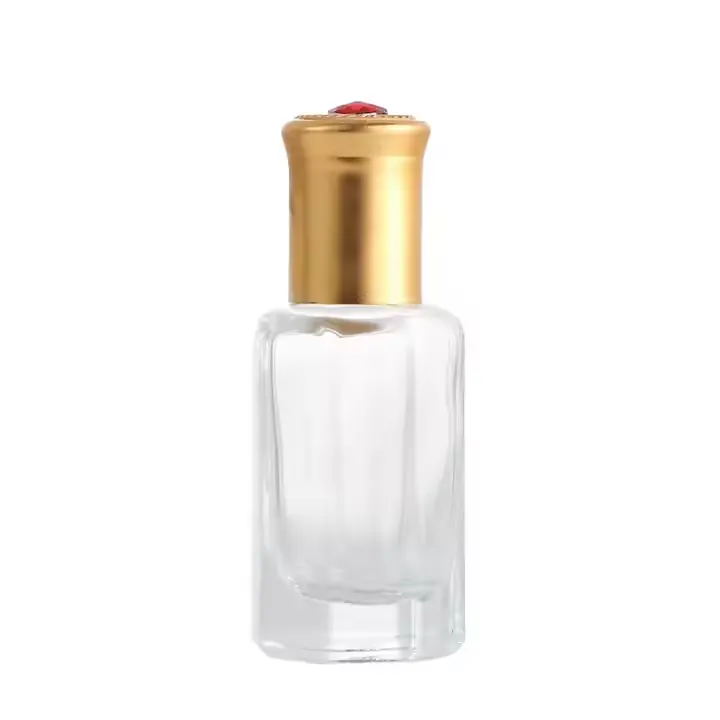 Small clear perfume bottle with tall gold cap and red top decoration