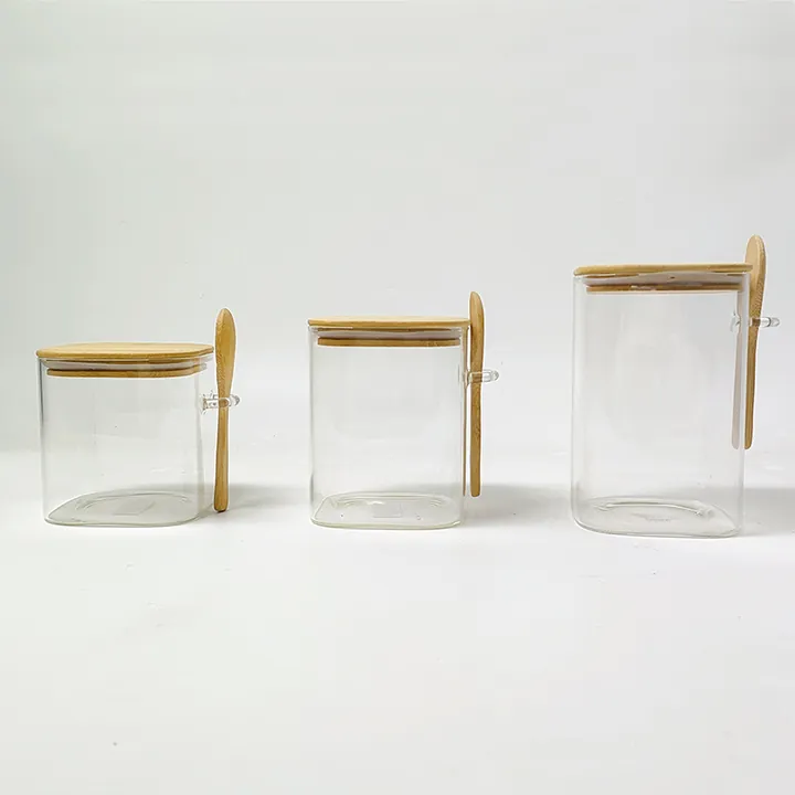 Square glass jars with bamboo lids and wooden spoons