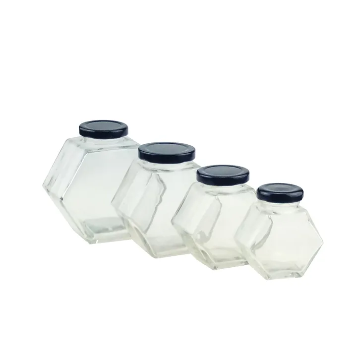 Four clear hexagon glass jars with black metal lids