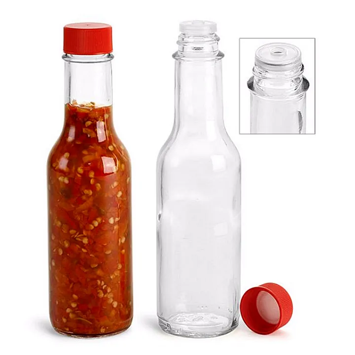 Red cap hot sauce bottle and clear empty bottle