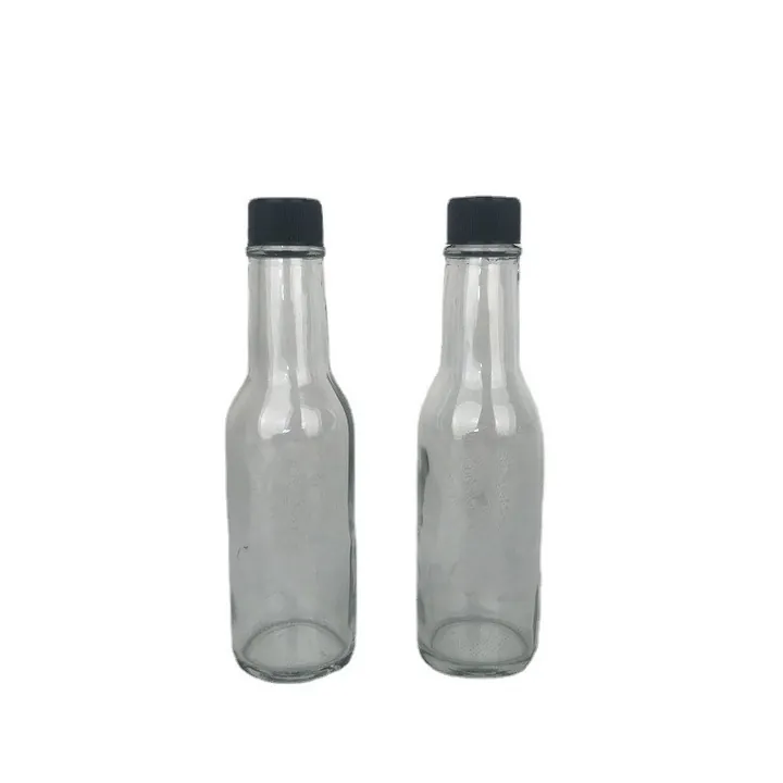 Two smoke glass hot sauce bottles with black caps