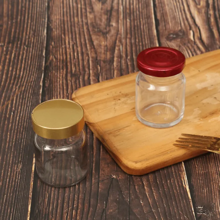 Small round jam jars displayed on wooden tray