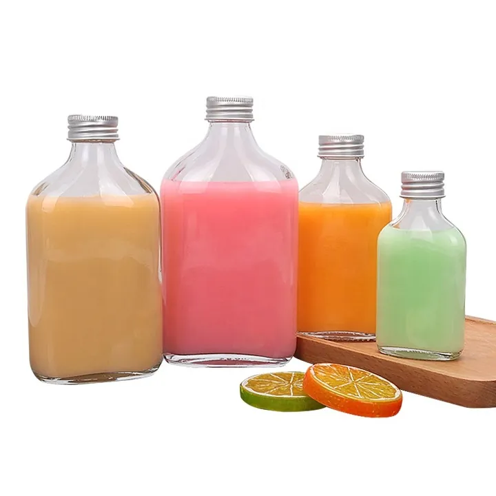 Flat square glass juice bottles with silver metal caps and colored drinks