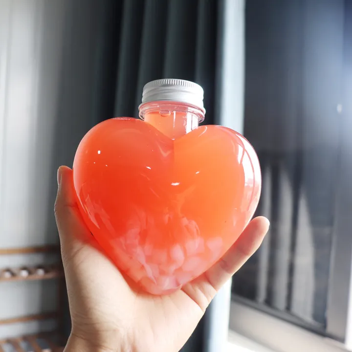 Herzförmige, durchsichtige Saftflasche mit rosa Getränk