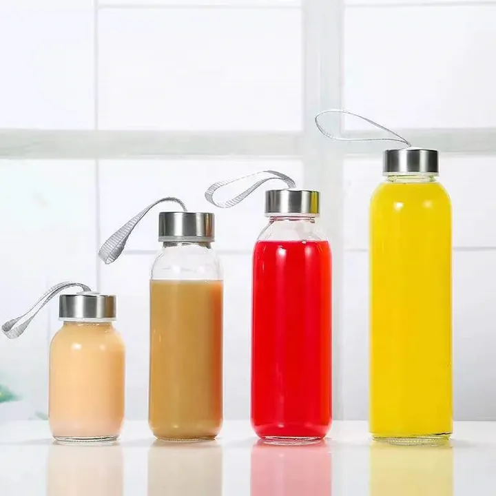 Saftflaschen aus klarem Glas mit Metallverschlüssen und farbigen Getränken