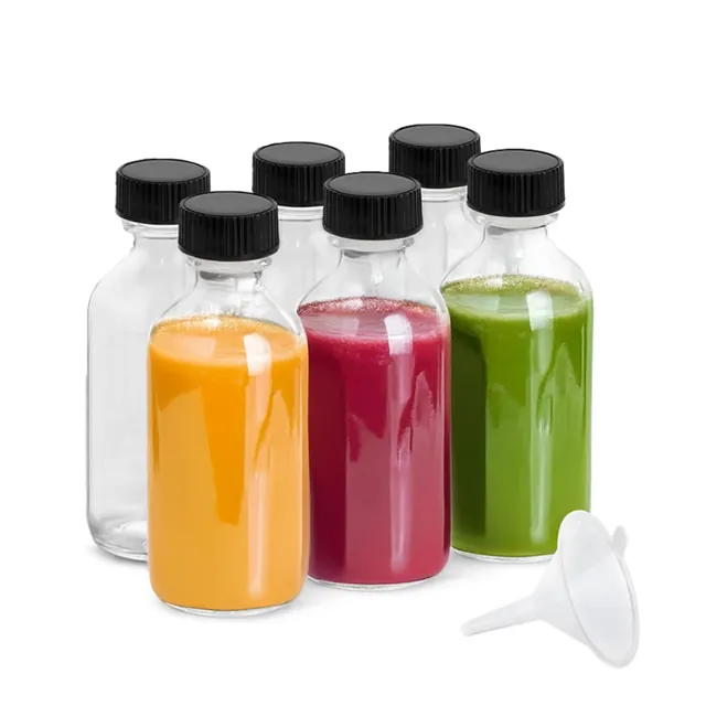 Small glass bottles with colorful beverages and black caps