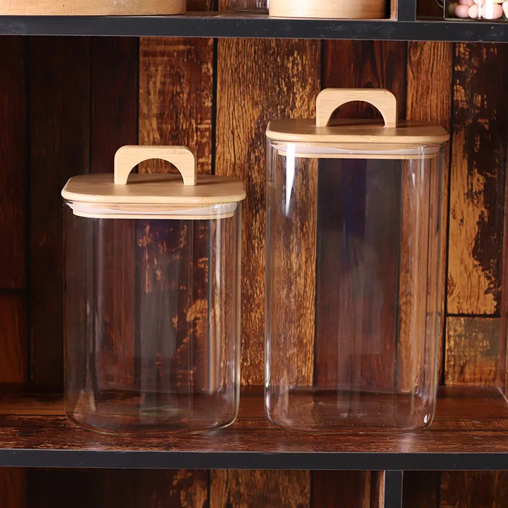 Deux bocaux de conservation en verre avec couvercles en bois et poignées de transport