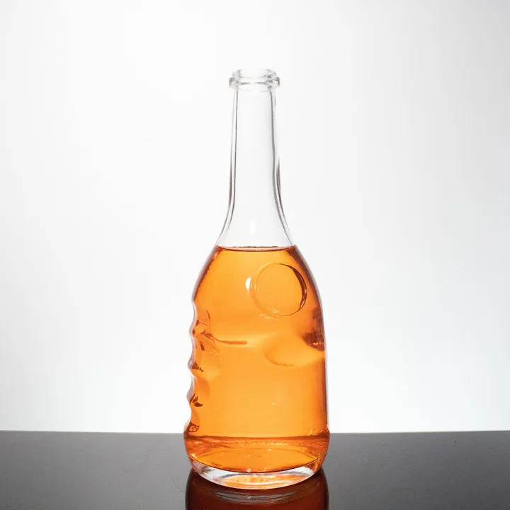 Botella de licor de cristal con la silueta de un rostro humano en el cuerpo