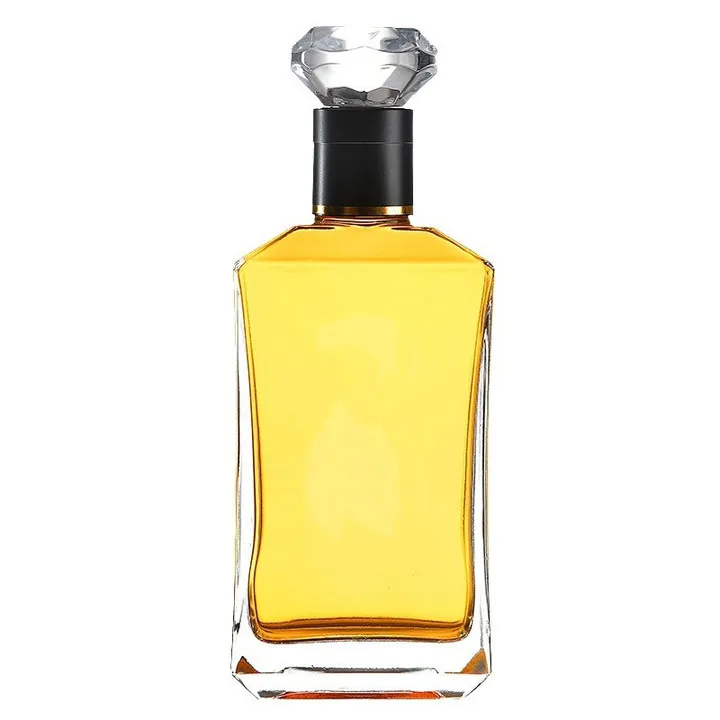 Clear liquor bottle with golden liquid black neck and crystal style stopper