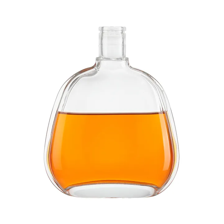 Botella de licor transparente, plana y de formas redondeadas, llena de licor de color ámbar