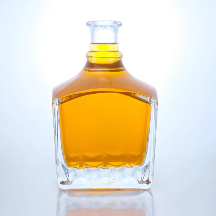 Square heavy base liquor bottle with golden liquid and cut pattern base