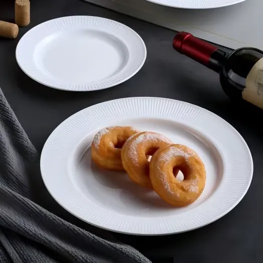 Assiettes opalescents à nervures blanches, présentées avec des plats et des accessoires de table