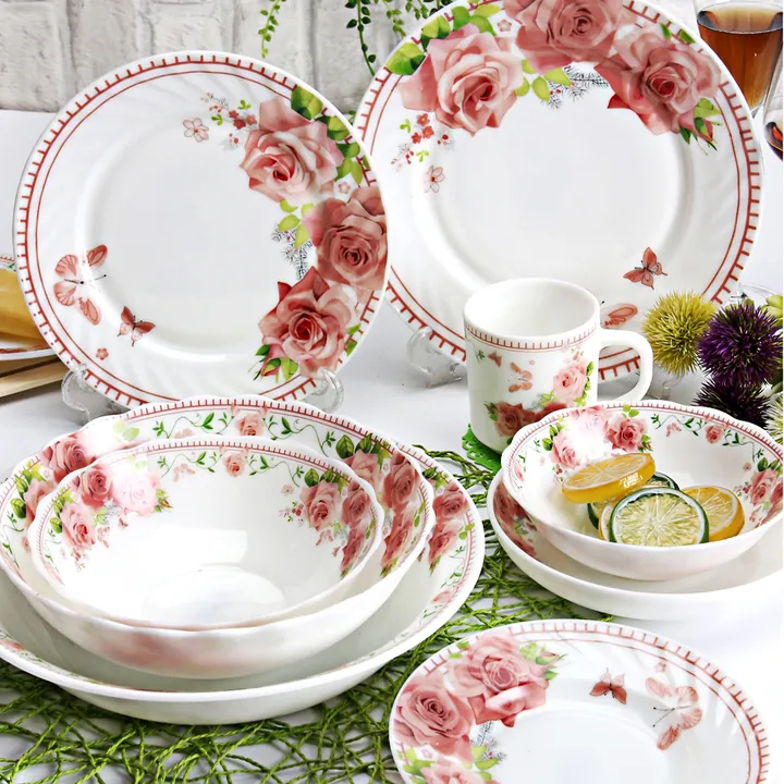 Assiettes, bols et tasses en opale à motifs de roses sur la table à manger