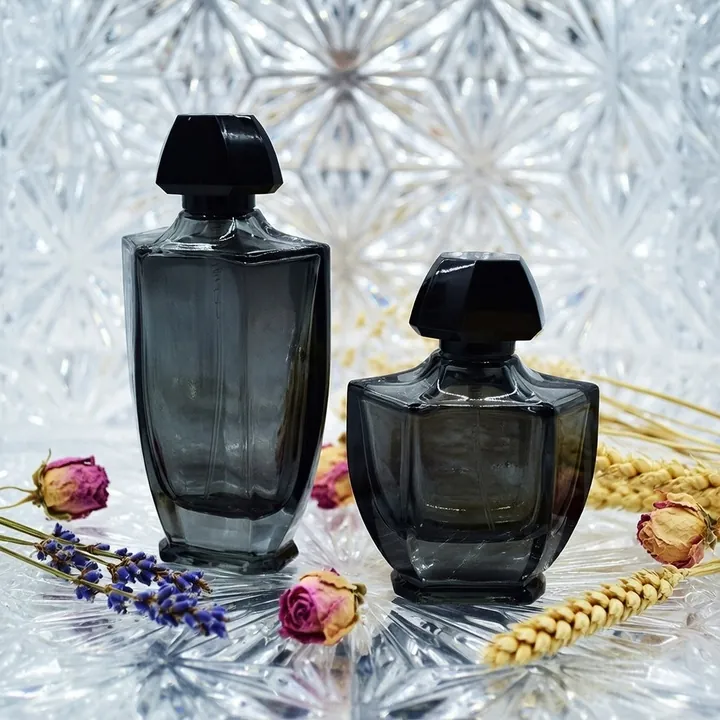 Two dark geometric perfume bottles with black polygon caps