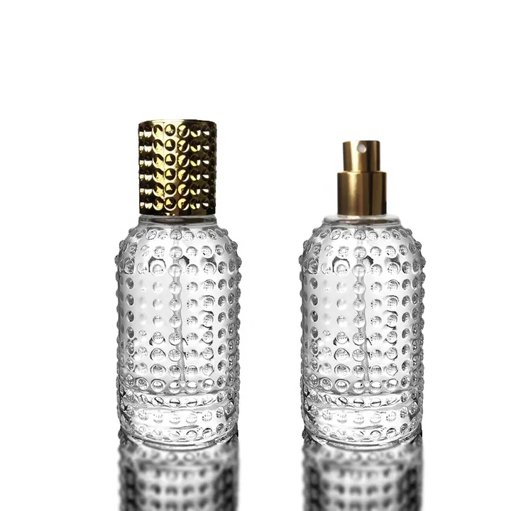 Frasco de perfume cilíndrico con textura de burbujas y pulverizador dorado