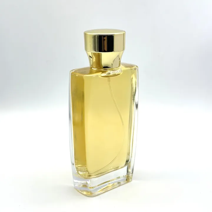 Frasco de perfume rectangular con líquido dorado y tapón dorado