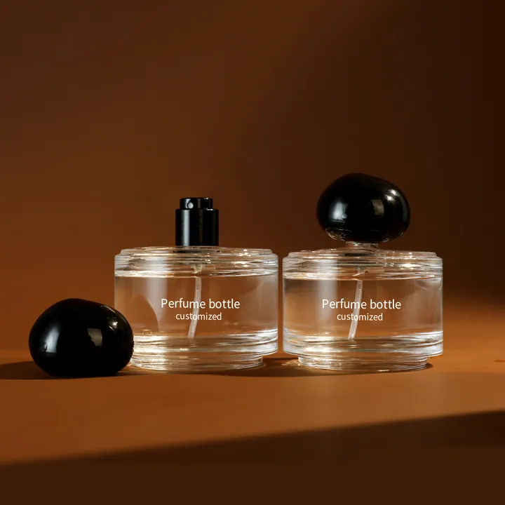 Dos frascos de perfume redondos y planos con texto impreso en blanco a medida
