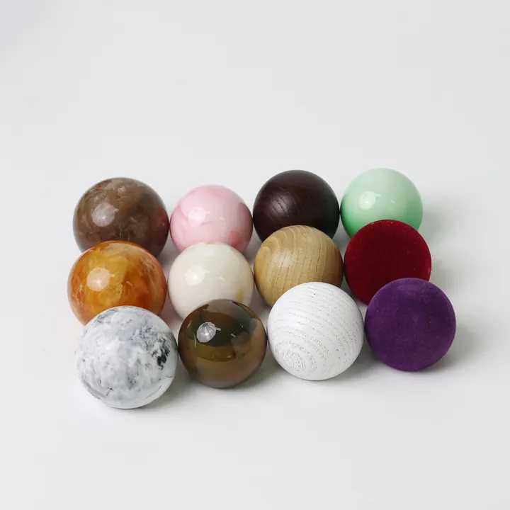 Multiple ball shaped perfume bottle caps in different colors and materials