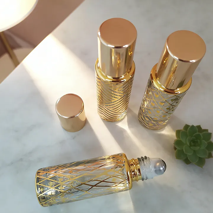 Clear perfume oil bottles with gold pattern decoration and roller heads