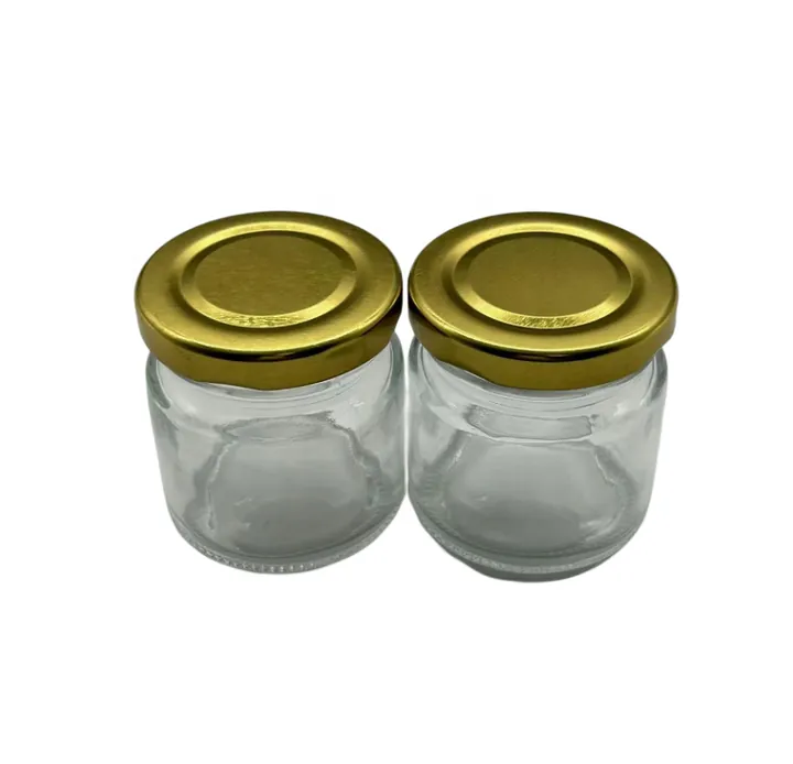 Two small round glass jars with gold metal lids