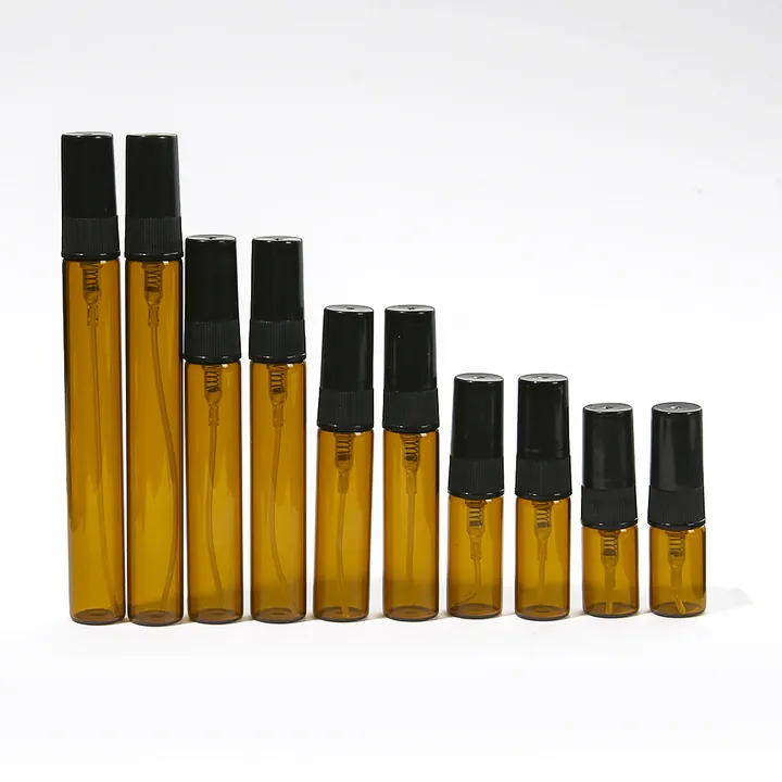 Small glass sample spray bottles in amber tones with black sprayers